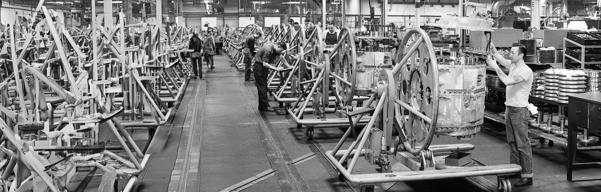 Black and white photo of a man working on a large transmission