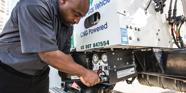 A photo of a man refueling a distribution truck that is powered by Compressed Natural Gas.