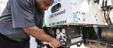 A photo of a man refueling a distribution truck that is powered by Compressed Natural Gas.