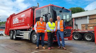 Three men in safety vests standing with red Biffa refuse truck