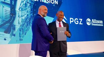 A representative from PGZ and Allison Transmission shake hands holding an MOU