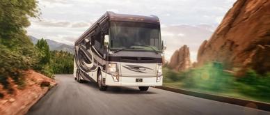 A photo of an RV driving on a road