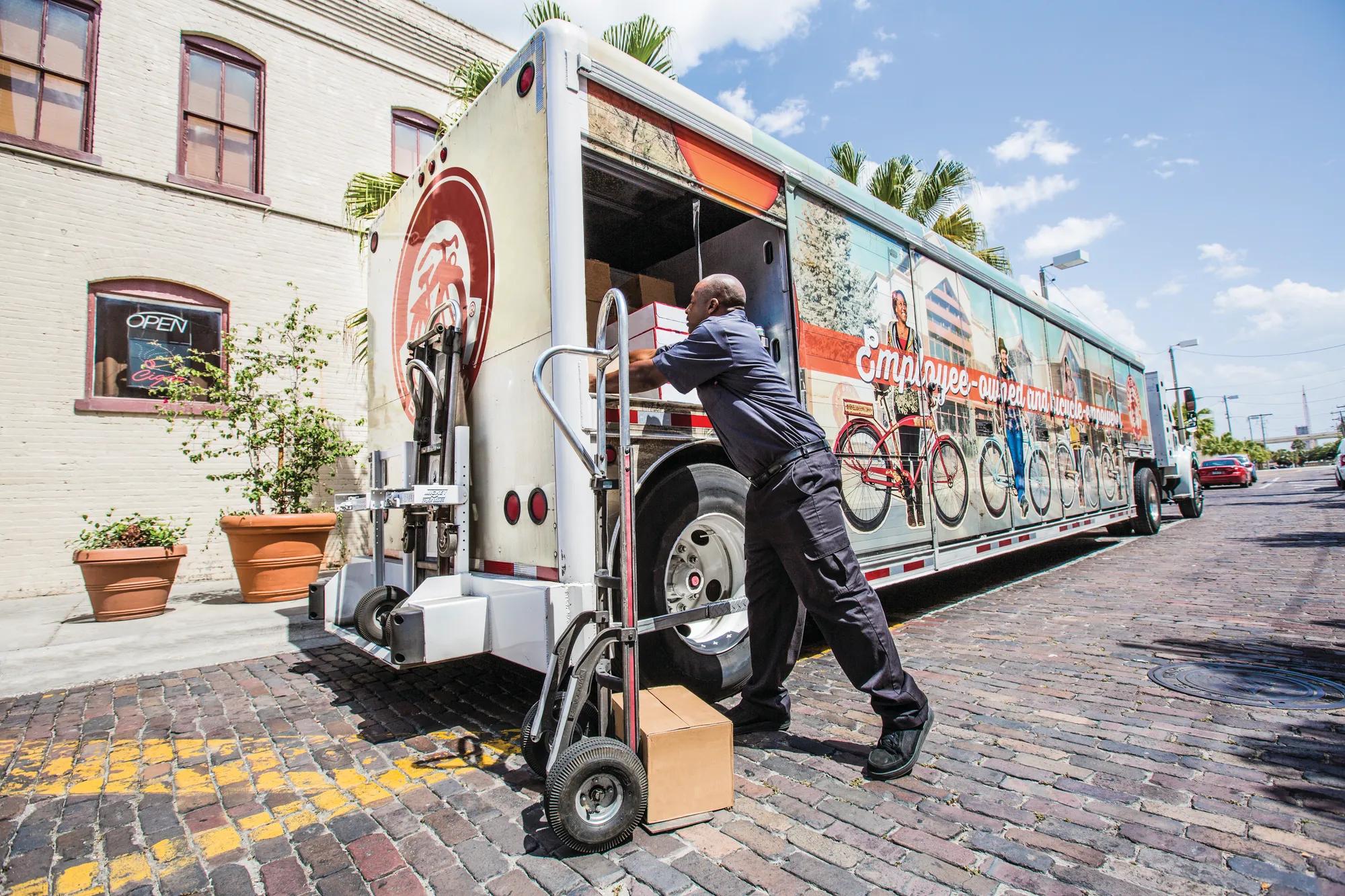 A photo of a food delivery truck with a worker in Florida.