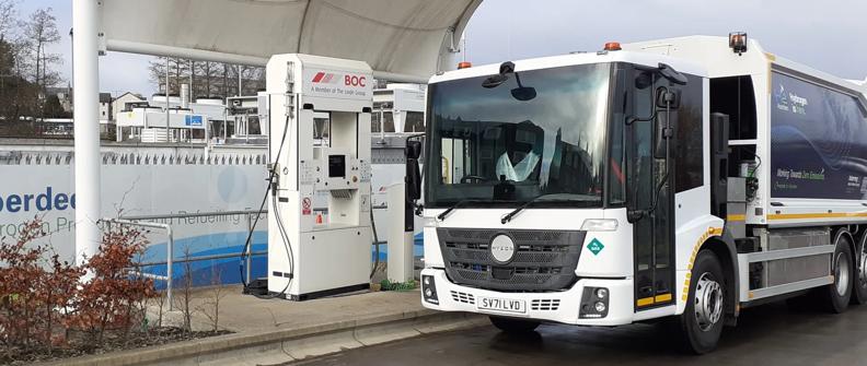 White Hyzon refuse truck in front of fuel pumps hydrogen fuel-cell